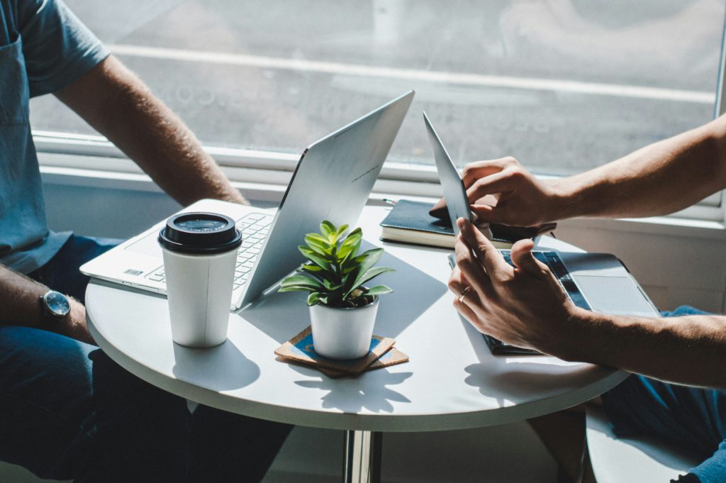 business meeting two people with laptops and coffee 