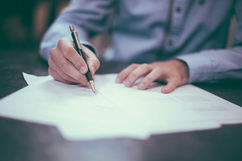 man writing on paper business documents accounting